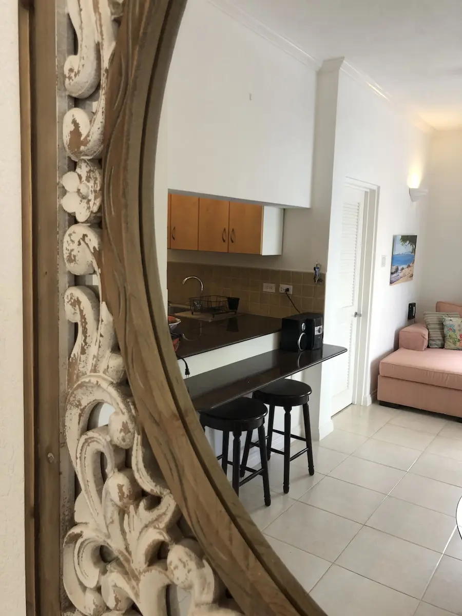 Fully equipped kitchen at 7 Springcourt seen through a carved mirror, with breakfast bar and stools.