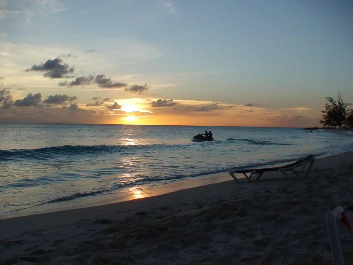 Jet ski cutting across the water at sunset on Accra Beach, Barbados.